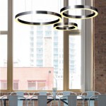 Lampa wisząca Circle D80 w kolorze niklowym, składająca się z trzech okrągłych pierścieni LED. Zawieszona w nowoczesnym wnętrzu, na tle dużych okien. Dwa źródła światła 40W, z możliwością sterowania pilotem.