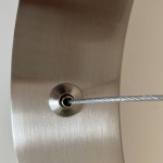 Zbliżenie na mocowanie lampy wiszącej Circle 40+60, z niklowym wykończeniem. Widoczny srebrny przewód zwieszający z zamocowaniem w metalowej podstawie. Struktura powierzchni matowa, z wyraźnym odcieniem niklu.