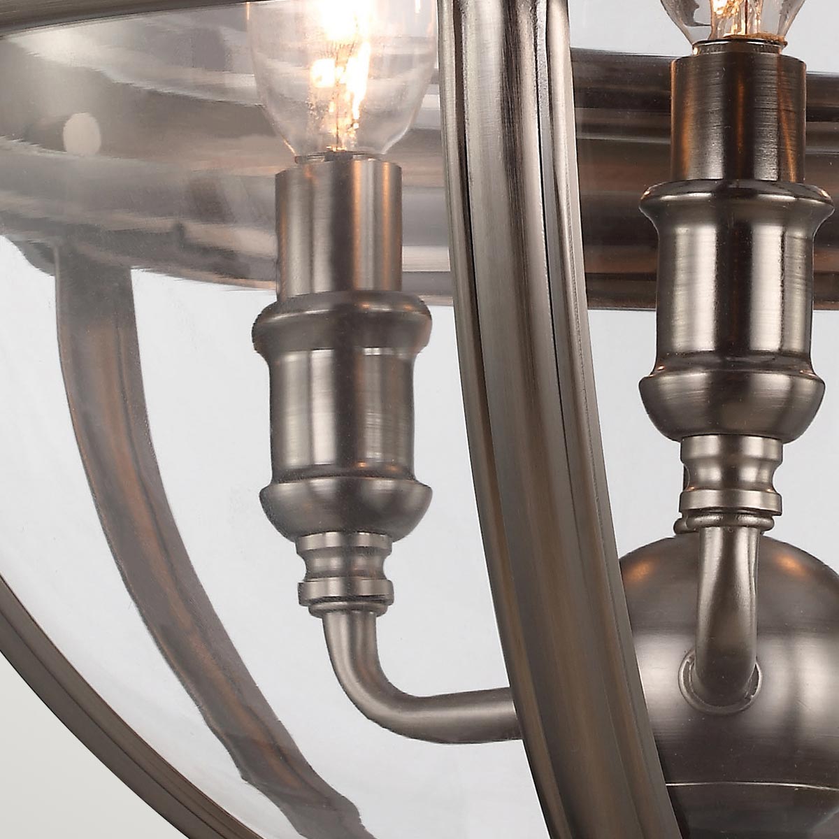 Lampa wisząca Adams 3xE14 w antycznym niklu. Zbliżenie na elementy konstrukcyjne, widoczne metalowe mocowania oraz przezroczystą osłonę żarówek. Elegancki design z wyraźnymi detalami i połączeniami.