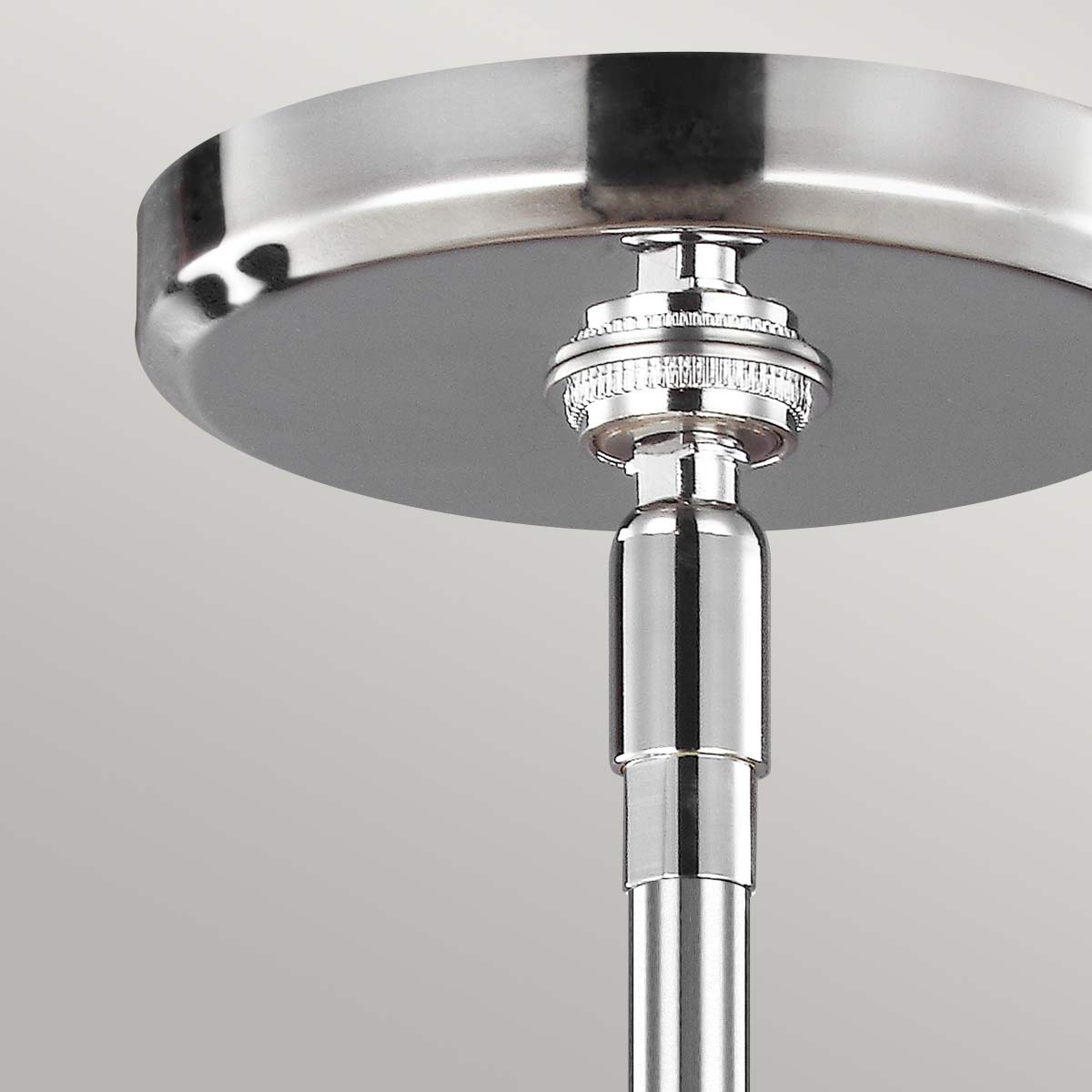Lampa wisząca Paulson IP44 z chromowanym wykończeniem, z widocznym detalem mocowania i regulowaną długością. Ujęcie z dołu, ukazujące sufitowy element montażowy oraz błyszczący, metaliczny wygląd.