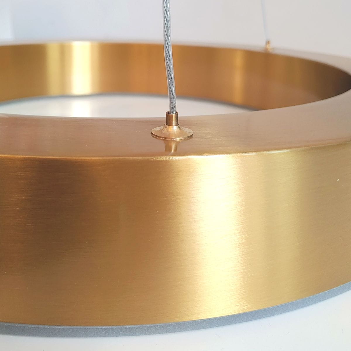 Lampa wisząca Circle 40+60+80 w kolorze mosiądzu, z widocznym detalem metalowego pierścienia i elementem mocującym. Ujęcie z bliska, ukazujące gładką, błyszczącą powierzchnię oraz zawieszenie. Produkt z pilotem, 3xLED/93W.