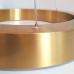 Lampa wisząca Circle 40+60+80 w kolorze mosiądzu, z widocznym detalem metalowego pierścienia i elementem mocującym. Ujęcie z bliska, ukazujące gładką, błyszczącą powierzchnię oraz zawieszenie. Produkt z pilotem, 3xLED/93W.