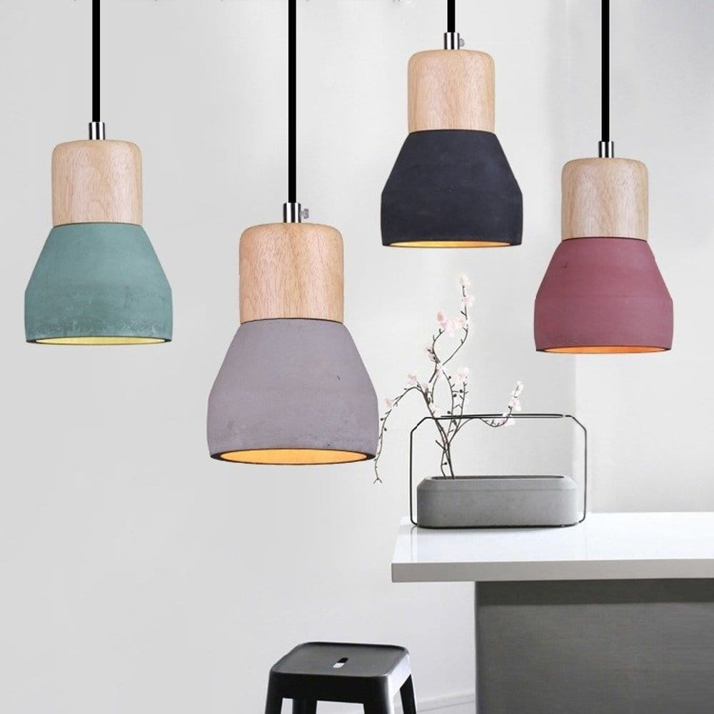 Lampa wisząca Concrete z czarnym betonem, wyposażona w drewniany klosz. Oferuje nowoczesny design z widocznymi detalami w różnych kolorach: czarnym, szarym, zielonym i różowym. Zawieszona na czarnym przewodzie, idealna do nowoczesnych wnętrz.