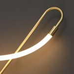 Złoty kinkiet Essa z jedną diodą LED 9W, o zaokrąglonym kształcie. Widoczny element lampy w formie giętego metalowego ramienia z delikatnym, białym źródłem światła. Ujęcie z góry, na jednolitym tle.