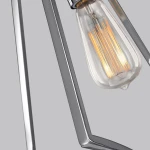 Lampa wisząca Nico XL z polerowanego chromu z widoczną żarówką E27. Ujęcie z bliska ukazuje detale metalowej konstrukcji oraz stylowy, szklany klosz z widoczną spiralą żarnika. Tło szare, skupiające uwagę na elemencie oświetleniowym.