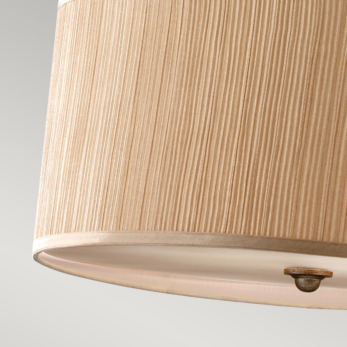 Lampa wisząca Abbey w kolorze antycznego srebra, z kloszem o fakturze z pionowymi liniami. Ujęcie z bliska ukazuje krawędź klosza, widoczne mocowanie. Produkt przeznaczony na trzy żarówki E27. Tło w odcieniu szaro-białym.
