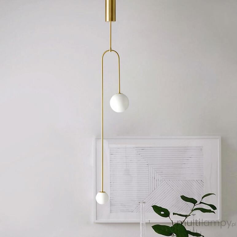 Lampa wisząca Loop 2xG9 w kolorze złotym, wykonana z metalu, z dwiema kulistymi kloszami w kolorze białym, zawieszona na cienkich linkach. Kąt ujęcia z boku, prezentujący minimalistyczny design w jasnym wnętrzu.