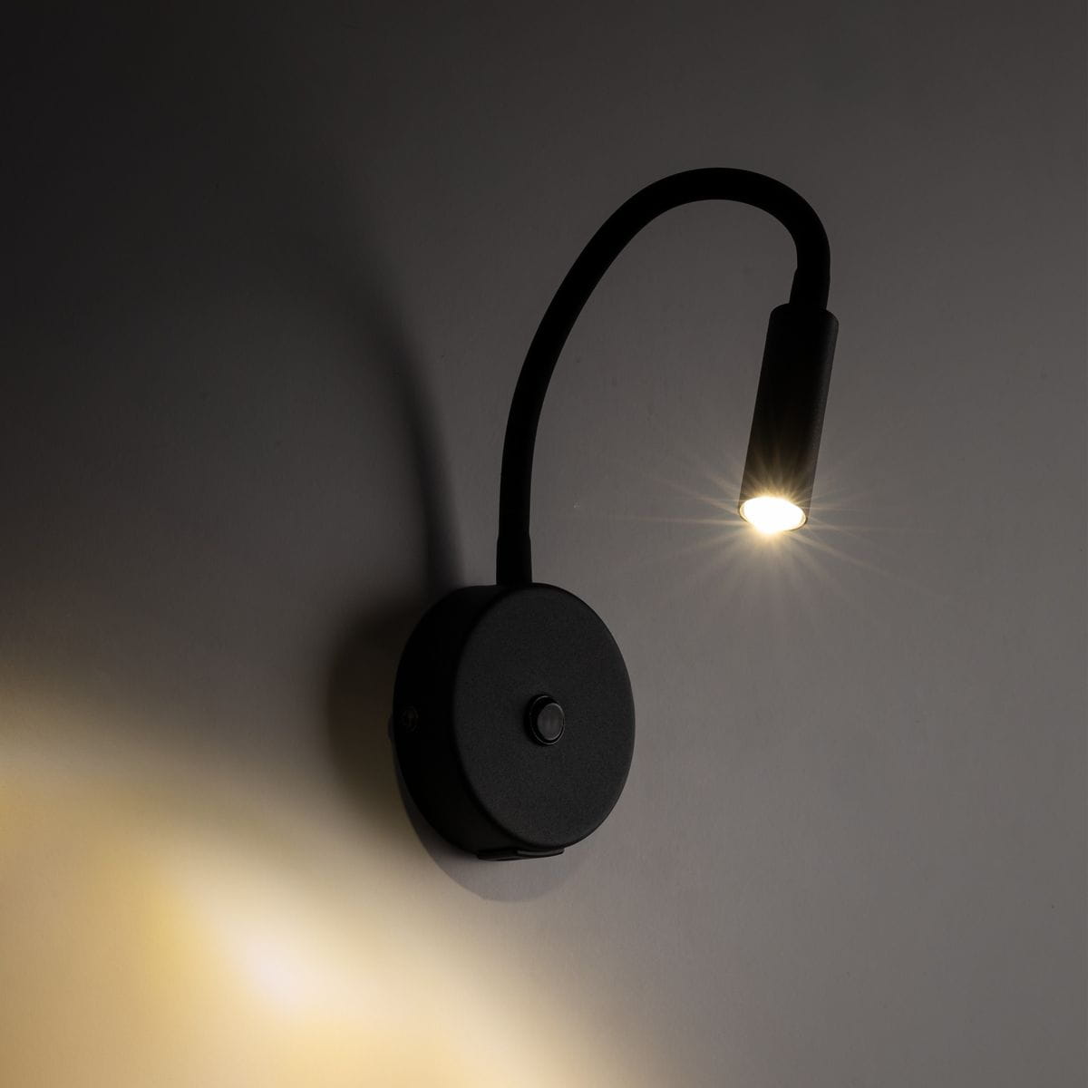 Kinkiet Lagos w kolorze czarnym z gniazdem USB, z elastycznym ramieniem i okrągłą podstawą. Lampa ma nowoczesny design i źródło światła G9. Ujęcie z boku, podkreślające kąt świecenia oraz detale konstrukcji.