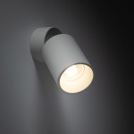 Biała lampa sufitowa typu spot z oprawą na żarówkę GU10, zamontowana na ścianie, z cylindrycznym kloszem skierowanym w dół. Prosta, matowa powierzchnia, minimalistyczny design, idealna do nowoczesnych wnętrz.