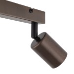 Brązowa lampa sufitowa typu spot z dwoma gniazdami GU10. Widać cylindryczny klosz zamocowany na ruchomej podstawie, zamontowany na prostokątnej, metalowej belce. Ujęcie z boku, podkreślające detale wykończenia.
