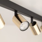 Top lampa sufitowa (spot) z ośmioma miejscami na żarówki GU10, w kolorze czarnym i złotym. Ujęcie z bliska na złoty reflektor na czarnym stelażu, ukazujący detal i fakturę materiału. Lampa montowana sufitowo, idealna do nowoczesnych wnętrz.