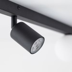 Czarna lampa sufitowa Vox z jednym źródłem światła GU10 i dwoma G9. Ujęcie z boku pokazuje cylindryczny klosz z matowym wykończeniem. Lampa zamontowana na prostokątnej podstawie, w minimalistycznym stylu, na jasnym tle.