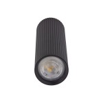 Lampa sufitowa Tune L w kolorze czarnym, z pojedynczym źródłem światła GU10. Owalny kształt z wyraźnym żłobieniem na powierzchni. Z przodu widoczna okrągła oprawa z przezroczystym kloszem. Produkt w pozycji stojącej, z bliska.