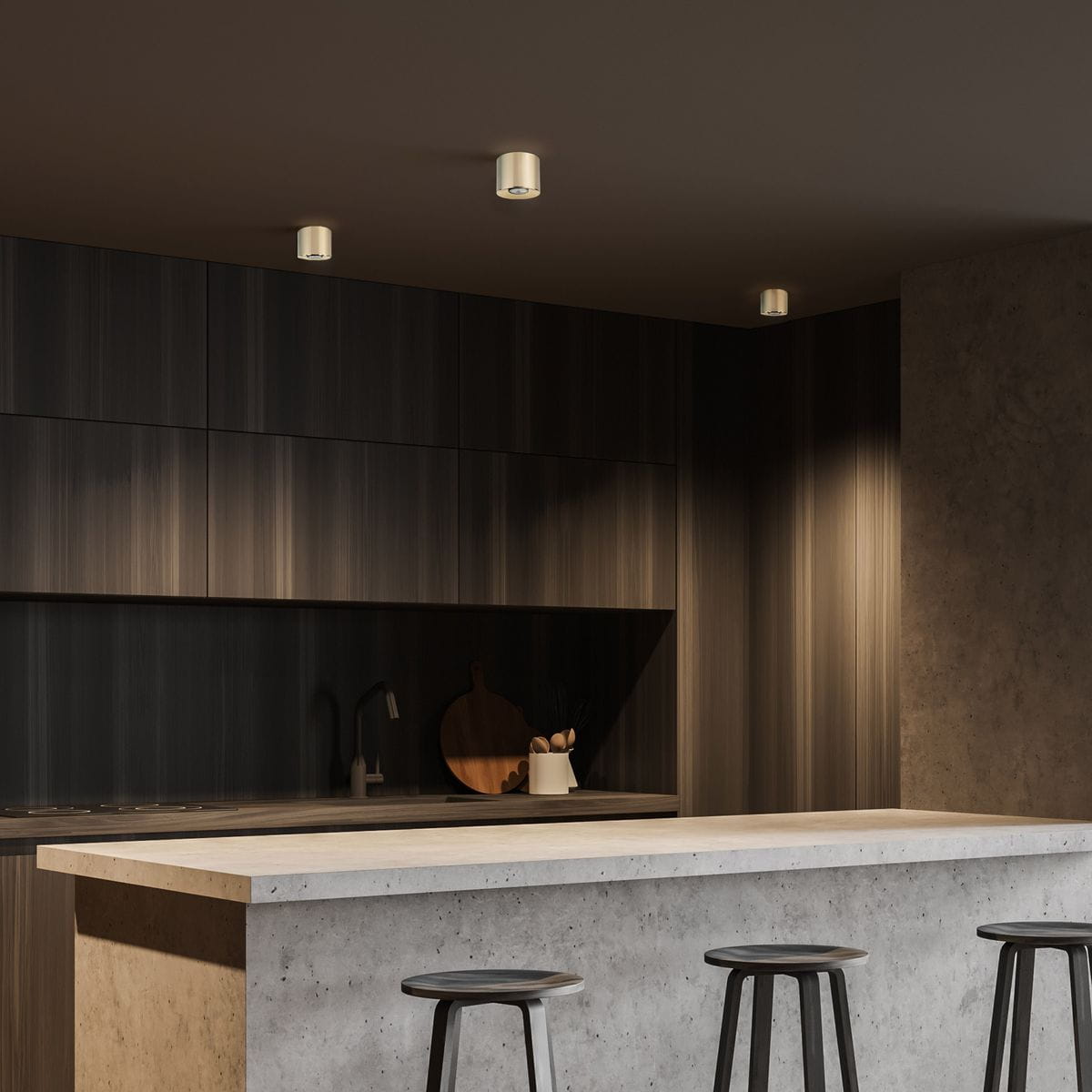 Lampa sufitowa Orion 1xGU10 w kolorze złotym, zamontowana na suficie w nowoczesnej kuchni. Widoczny minimalistyczny design oraz dwa źródła światła, oświetlające ciemne drewniane szafki. Tło w odcieniach szarości i drewna, z betonowym blatem.