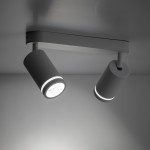 Lampa sufitowa Jet z dwoma reflektorami GU10 w kolorze białym, zamontowana na prostokątnej podstawie. Reflektory mają cylindryczny kształt z delikatnym, białym pierścieniem świetlnym. Ujęcie z dołu, ukazujące detale lampy.