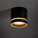 Czarna lampa sufitowa Jet z oprawą GX53, okrągła, z widocznymi dwoma złotymi pierścieniami dekoracyjnymi. Ujęcie z dołu ukazuje elegancki, minimalistyczny design i źródło światła w centrum.