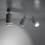 Lampa sufitowa Jet w białym kolorze, składająca się z trzech reflektorów na metalowej podstawie. Reflektory mają okrągłe kształty z podświetleniem na brzegach, zamontowane prostopadle do sufitu.