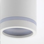 Biała lampa sufitowa Jet z oprawą na jedną żarówkę GU10. Okrągła konstrukcja z matowego materiału, z widocznym szklanym kloszem, w dolnej części z delikatnym, niebieskim akcentem. Ujęcie z bliska, ukazujące detale wykończenia.