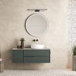 Kinkiet Gallery IP44 w kolorze czarnym, z jedną żarówką LED 20W, zamontowany nad okrągłym lustrem. Produkt umieszczony w nowoczesnej łazience na tle gładkiej, jasnej ściany. W pobliżu widoczne umywalka oraz dekoracje.