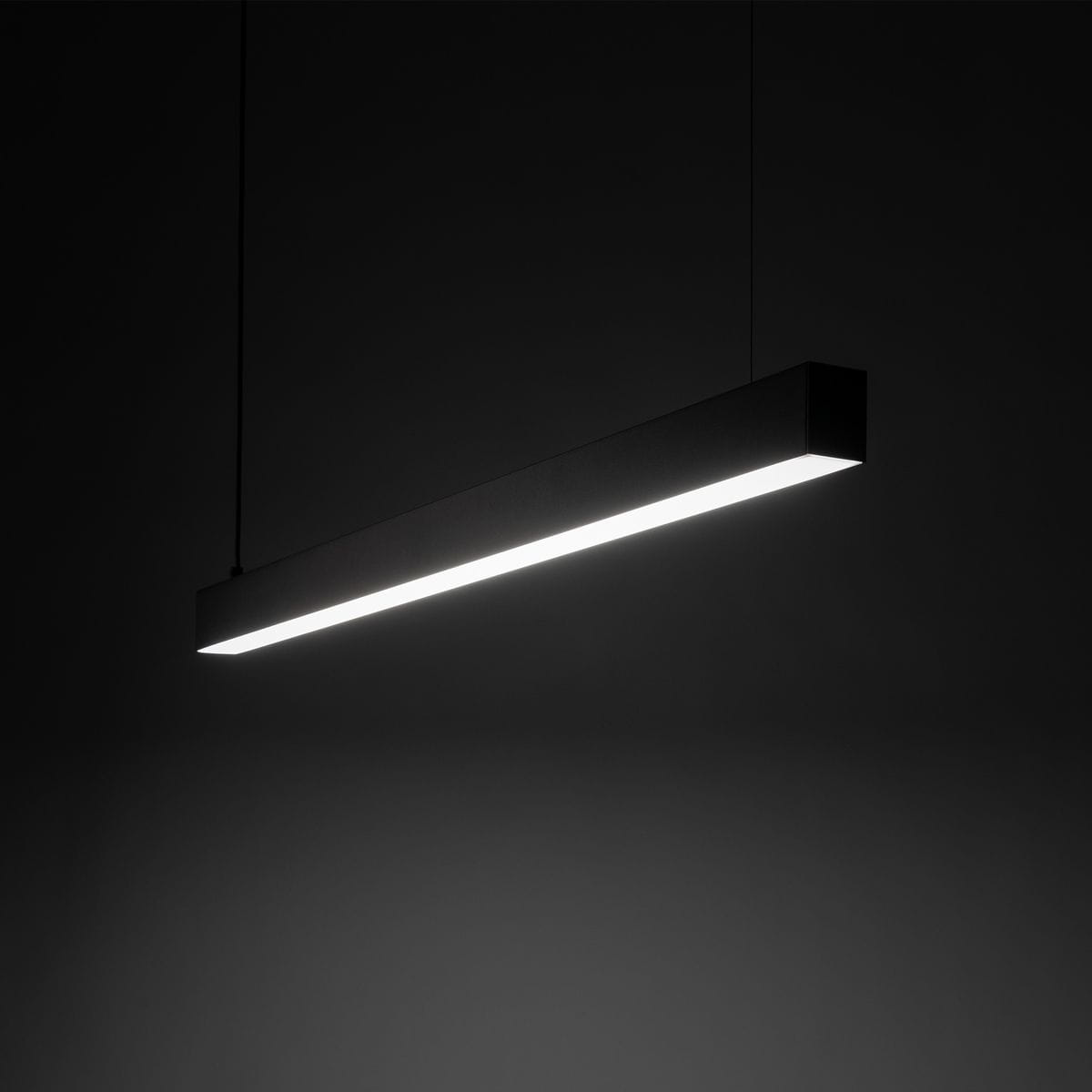 Lampa wisząca Luxe IP54, czarna, o prostokątnym kształcie. Zawiera jedno źródło światła LED o mocy 40W. Zawieszona na cienkich linkach, emituje jasne, białe światło z wąskim paskiem świetlnym na dolnej krawędzi. Idealna do nowoczesnych wnętrz.