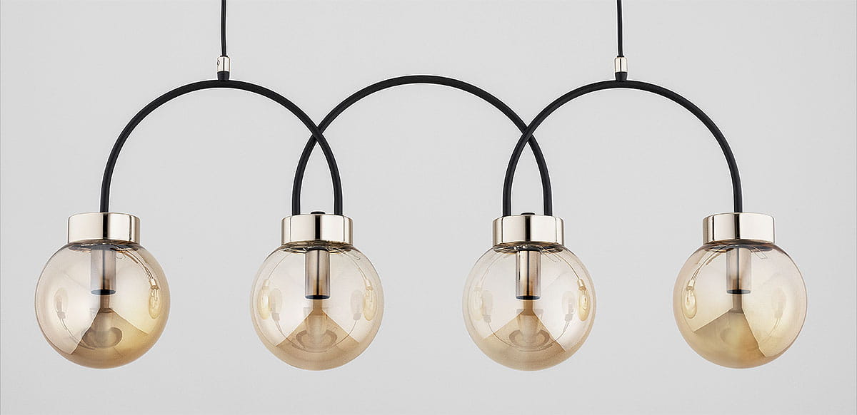 Lampa wisząca Darso 4xE14 w kolorze czarnym z bursztynowymi kloszami. Cztery okrągłe, przezroczyste klosze z metalowymi detalami, zawieszone na czarnych łukach. Ujęcie frontalne, na jednolitym tle.