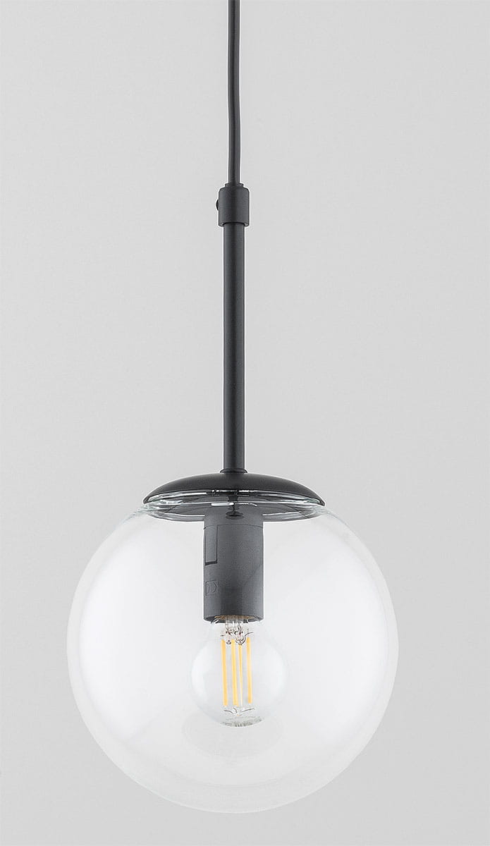 Czarna lampa wisząca Sebia z jedną oprawą E14. Okrągła, przezroczysta szklana kula z widoczną żarówką. Kąt ujęcia z góry, zawieszona na cienkim kablu. Tło jasnoszare, proste, co podkreśla design lampy.