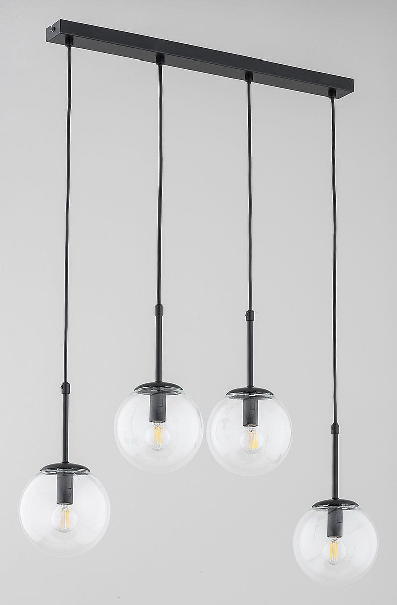 Lampa wisząca Sebia z czterema kulistymi kloszami w przezroczystym, szklanym materiale. Czarna, metalowa konstrukcja z prostokątnym stelażem. Klosze zawieszone na cienkich, czarnych linkach, eksponujące źródła światła E14.