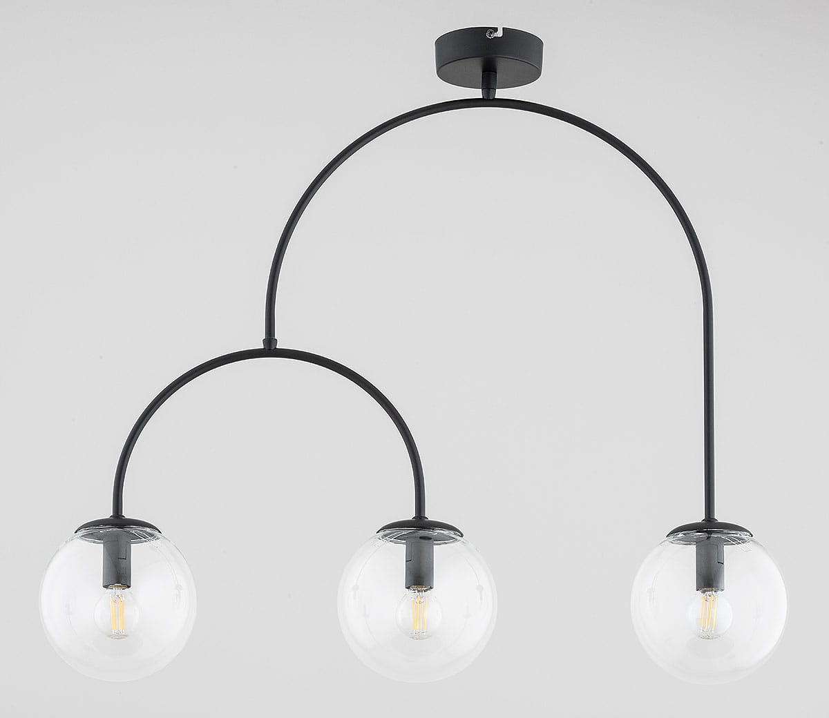 Lampa wisząca Dilar z trzema kloszami E14 w kształcie kulistym, wykonana z czarnego metalu. Klosze szklane, przezroczyste, z widocznymi żarówkami. Ujęcie frontalne, wisząca, montowana sufitowo. Proste tło, podkreślające elegancki design.