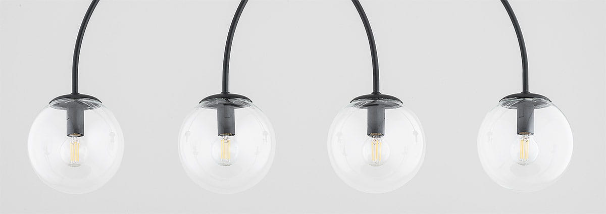 Lampa wisząca Dilar 4xE14 w kolorze czarnym z czterema przezroczystymi kloszami w kształcie kul, zawieszona na elastycznych przewodach. Klosze mają metalowe mocowania, tworząc nowoczesny wygląd. Tło białe, co podkreśla detale lampy.