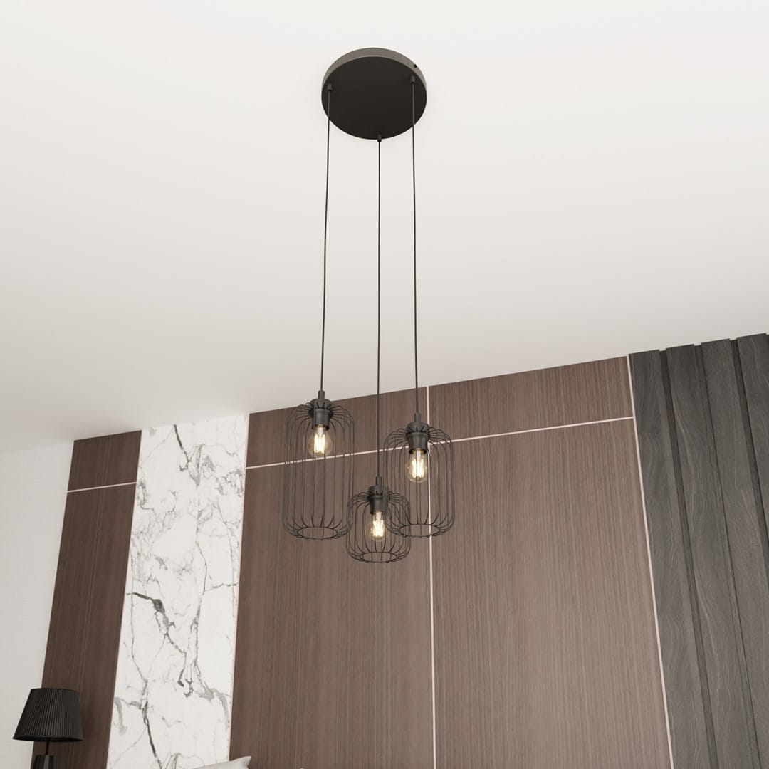 Lampa wisząca Vander 3xE27 w kolorze czarnym, z trzema kloszami w metalowej siatce, zawieszona na długich linkach. Ujęcie z dołu, pokazujące sufit i elementy drewnianej ściany w tle.