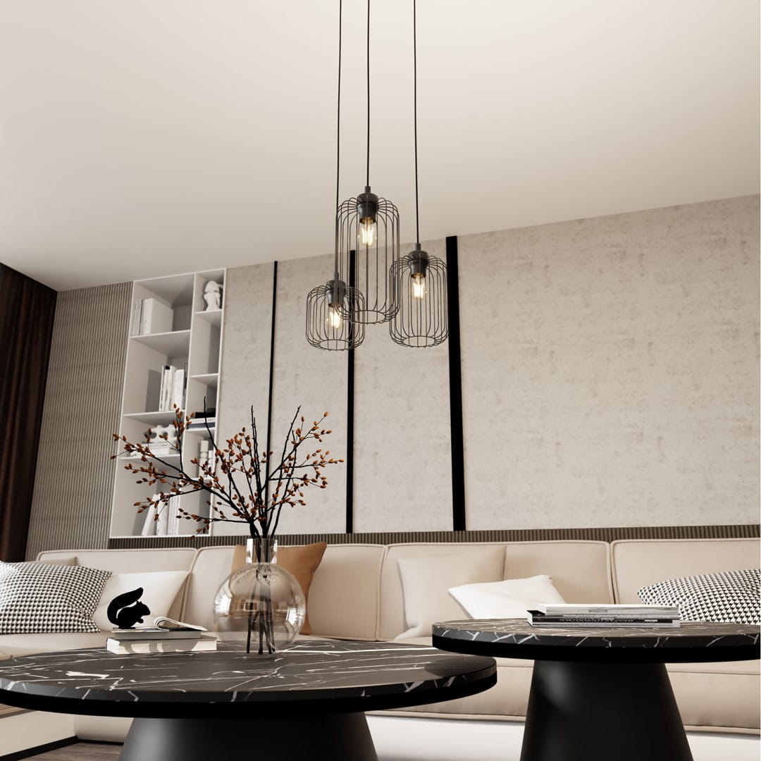 Lampa wisząca Vander 3xE27 w czarnej metalowej obudowie, z trzema kloszami w formie siatki, zawieszona nad stolikami kawowymi w nowoczesnym wnętrzu. Tło jasne, z elementami dekoracyjnymi w aranżacji.
