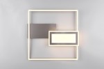 Lampa sufitowa Spiro w kolorze niklu, z dwiema diodami LED (32W). Ma nowoczesny, geometryczny kształt z prostokątnymi elementami oraz podświetleniem. Montowana na ścianie, z pilotem do zdalnego sterowania. Tło jasnoszare.