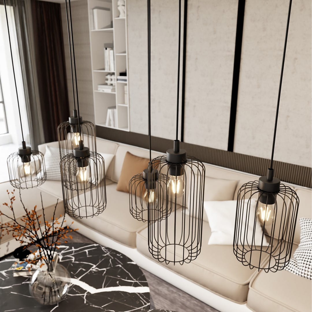 Lampa wisząca Vander 6BL z sześcioma kloszami w czarnym metalowym wykończeniu, zawieszona na długich przewodach. Klosze w formie siatki z widocznymi żarówkami E27, umiejscowiona nad sofą w nowoczesnym wnętrzu. Tło z jasnymi panelami i książkami.