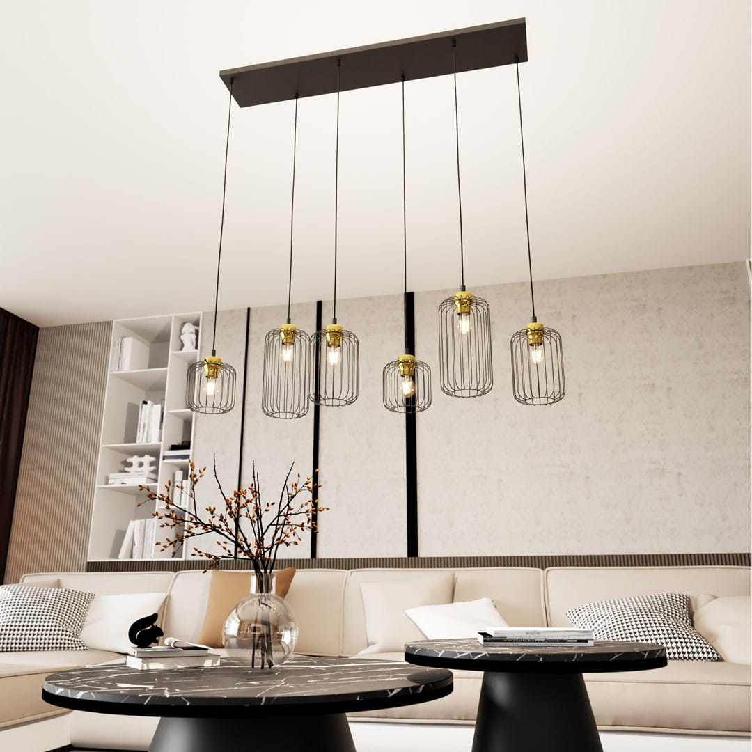 Lampa wisząca Vander 6 z sześcioma kloszami w czarnej metalowej siatce z złotymi detalami, zawieszona na prostokątnej podstawie. Produkt wisi nad stolikami w nowoczesnym wnętrzu z jasną sofą i dekoracjami.