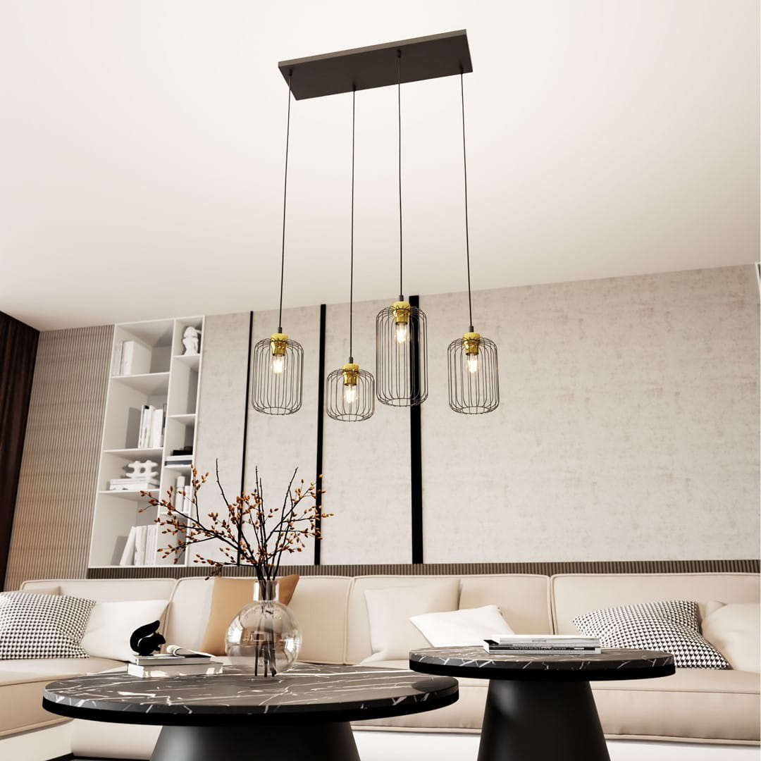 Lampa wisząca Vander 4 z czarnym, prostokątnym stelażem i czterema kloszami z metalowej siatki w złotym wykończeniu. Zawieszona na cienkich linkach, w nowoczesnym wnętrzu, nad okrągłym stolikiem. W tle jasna ściana oraz meble w neutralnych kolorach.