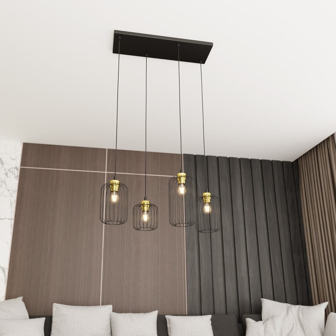 Lampa wisząca Vander 4 z czarno-złotym wykończeniem, zawieszona na czterech cienkich linkach. Posiada cztery klosze w formie siatkowych osłon z żarówkami E27, umieszczona pod sufitem, na tle drewnianej ściany.