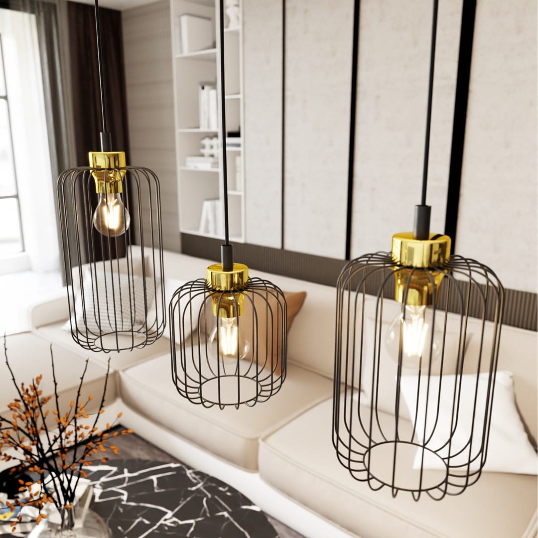 Lampa wisząca Vander 3GL w kolorze czarnym i złotym, składająca się z trzech kloszy w formie siatki. Klosze mają złote mocowania, w każdym znajduje się żarówka. Lampa zawieszona na długich kablach, w tle jasny salon z sofą i stołem.