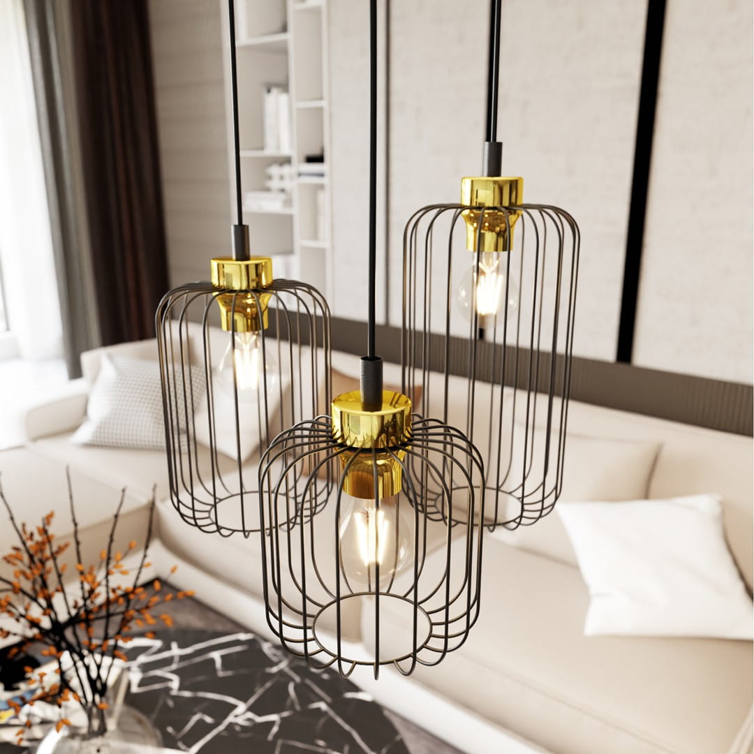 Lampa wisząca Vander 3 z trzema kloszami w czarnym kolorze z metalową złotą podstawą. Klosze mają siatkową konstrukcję, zawieszone na czarnych linkach. W tle widoczna kanapa i dekoracje w nowoczesnym wnętrzu.