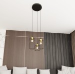 Lampa wisząca Vander 3 z trzema kloszami w czarnym metalowym wykończeniu i złotymi detalami. Zawieszona na dwóch cienkich linkach, wisi pod sufitem, w tle jasna ściana z tapetą i szarym obiciem sofy.