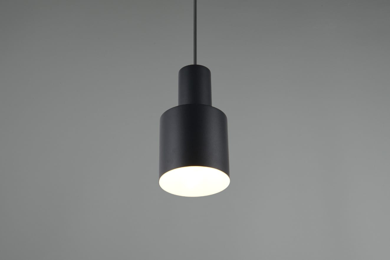 Czarna lampa wisząca Agudo z jednym gniazdem E27, o cylindrycznym kształcie. Ujęcie z przodu, zawieszona na cienkim przewodzie, z białym kloszem emitującym światło. Tło w szarym odcieniu, podkreślające minimalistyczny design produktu.