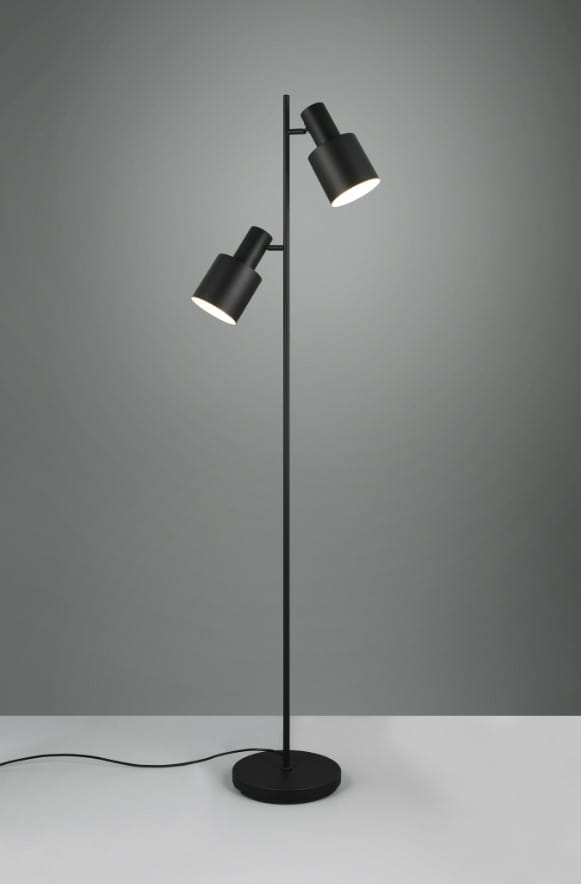 Lampa podłogowa Agudo w kolorze czarnym z dwoma ruchomymi kloszami na cienkiej, prostokątnej nodze. Stoi na okrągłej podstawie z przewodem elektrycznym widocznym na podłodze. Tło w odcieniu szarości.