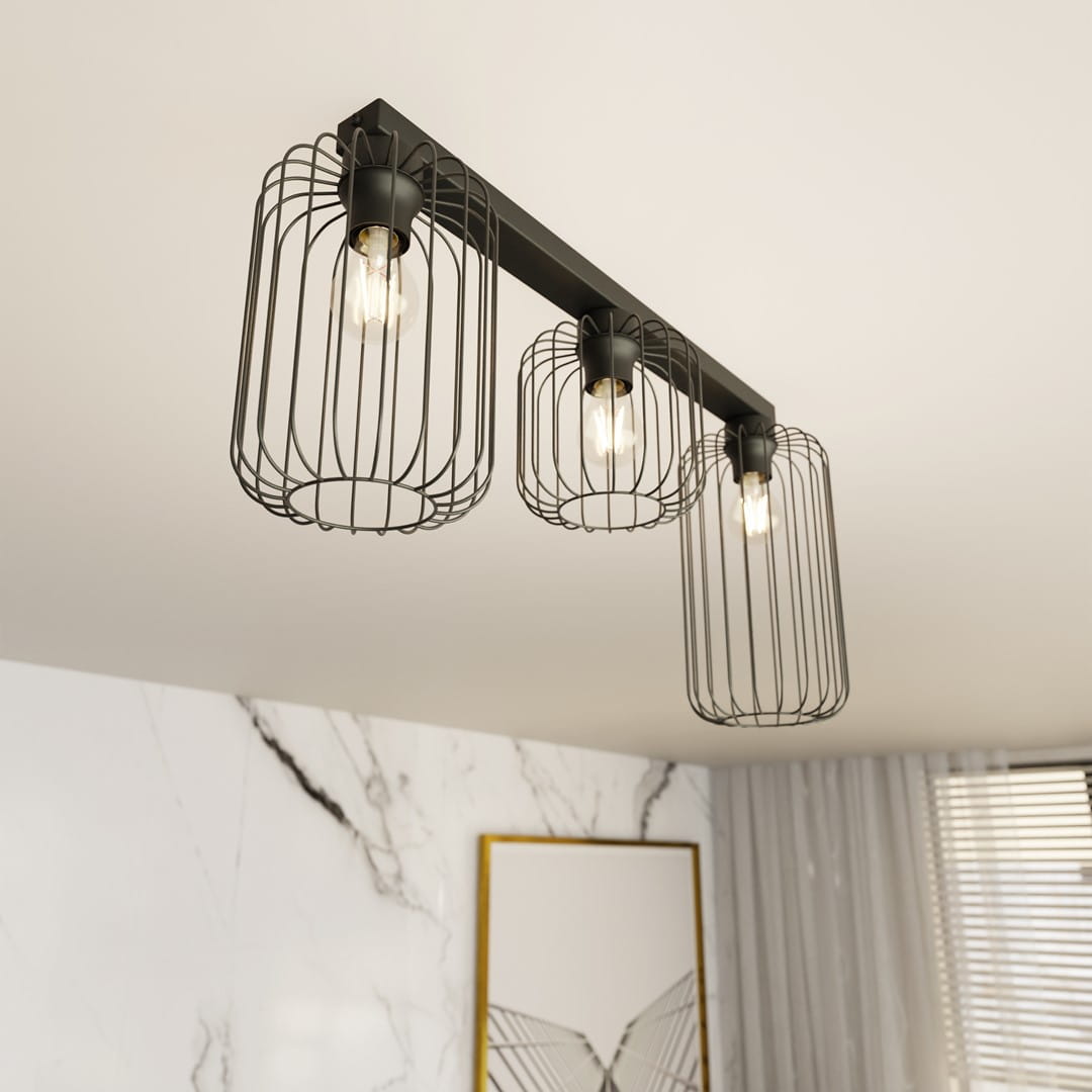 Lampa sufitowa Barn 3BL w kolorze czarnym, z trzema kloszami w formie siatki, z trzema gniazdami E27. Ujęcie z dołu, montowana na suficie, idealna do nowoczesnych wnętrz. Widoczne ciepłe światło żarówek. Tło w jasnych tonacjach.