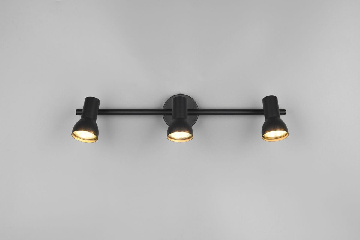 Cantar lampa sufitowa w kolorze czarnym z trzema reflektorami GU10. Montaż na ścianie, z równomiernym rozkładem światła. Reflektory mają cylindryczny kształt, matowe wykończenie, a ich wnętrze jest w kolorze złotym. Tło jasnoszare.
