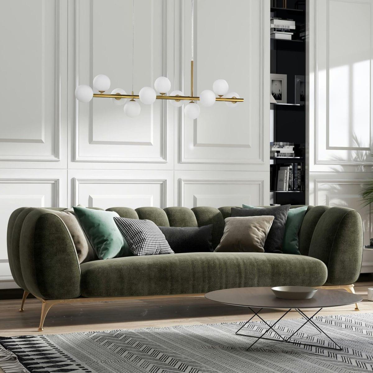 Lampa wisząca Mini Moon w kolorze złotym szczotkowanym z 11 źródłami światła G9, zawieszona nad zieloną sofą. Kształt owalny z białymi kloszami, w nowoczesnym wnętrzu z białymi ścianami i ciemnymi meblami.