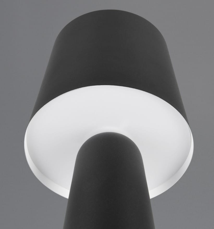 Czarna lampa stołowa Nubian z oprawą na żarówkę E27, z okrągłym kloszem i prostą, cylindryczną podstawą. Ujęcie z dołu, ukazujące gładką fakturę materiału oraz białe wnętrze klosza.