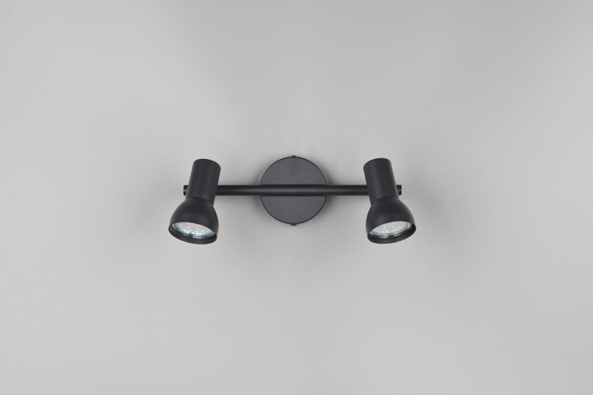 Cantar lampa sufitowa (spot) w kolorze czarnym, z dwoma oprawami na żarówki GU10. Ułożona poziomo, z okrągłą podstawą i regulowanymi ramionami reflektorów, które emitują skierowane światło. Tło jasnoszare, prosty design.