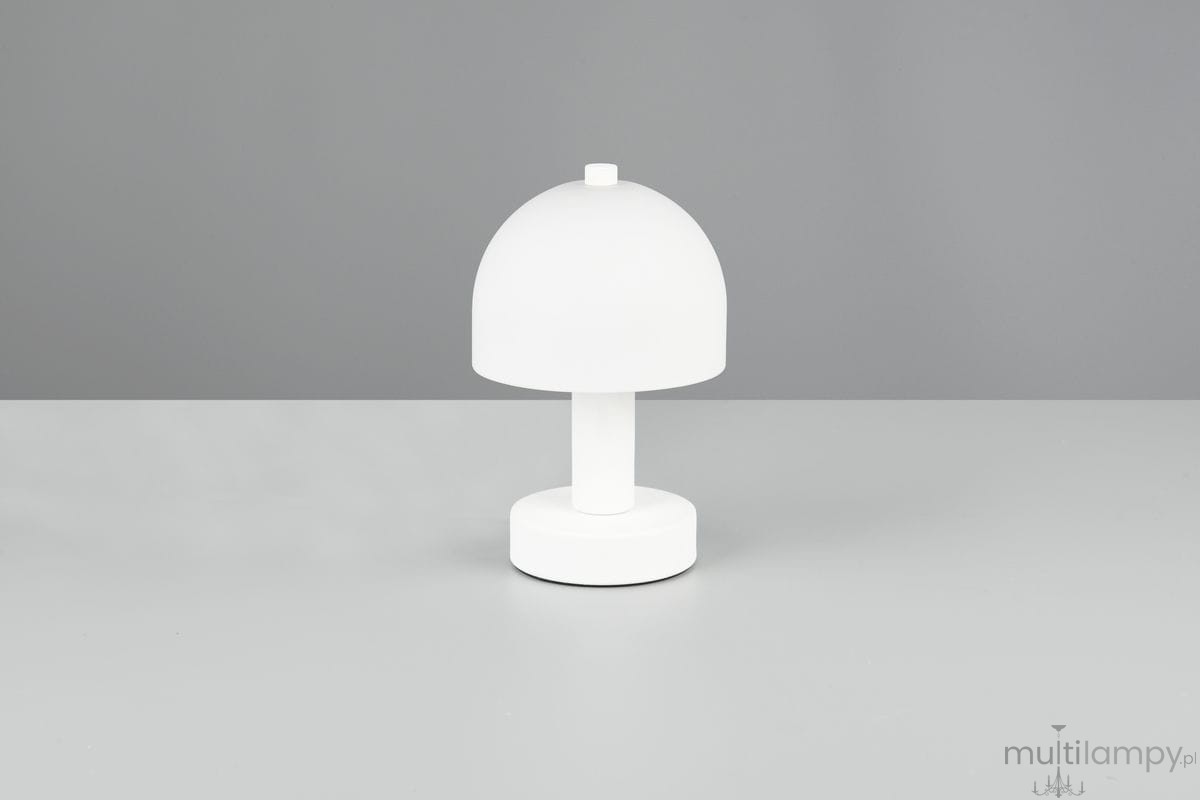 Biała lampa stołowa Glenn z kloszem w kształcie półkuli, na okrągłej podstawie. Ujęcie frontalne, produkt stoi na szarej powierzchni. Lampa przeznaczona na żarówkę E14.