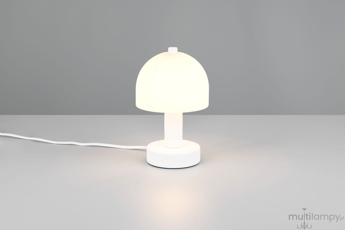 Biała lampa stołowa Glenn z kloszem w kształcie półkuli, umieszczona na okrągłej podstawie. Kable w białym kolorze, lampa o jednym gnieździe E14, zapalana, z lekkim świeceniem. Ujęcie frontalne na jednolitym tle.