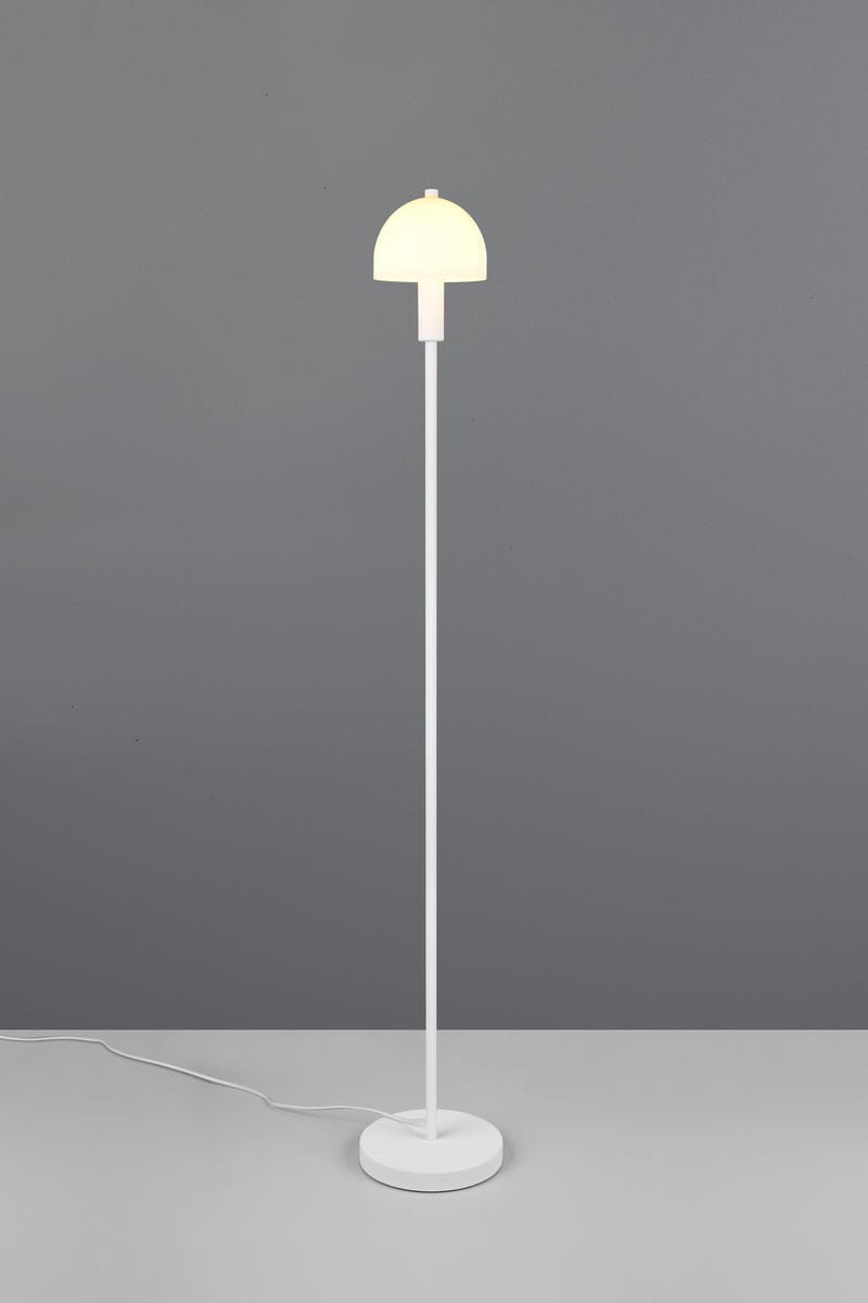 Lampa podłogowa Glenn w białym kolorze z okrągłą podstawą. Posiada smukły, prosty korpus oraz klosz w kształcie półkuli. Ujęcie frontalne, lampa stoi na szarej powierzchni, z widocznym kablem zasilającym.