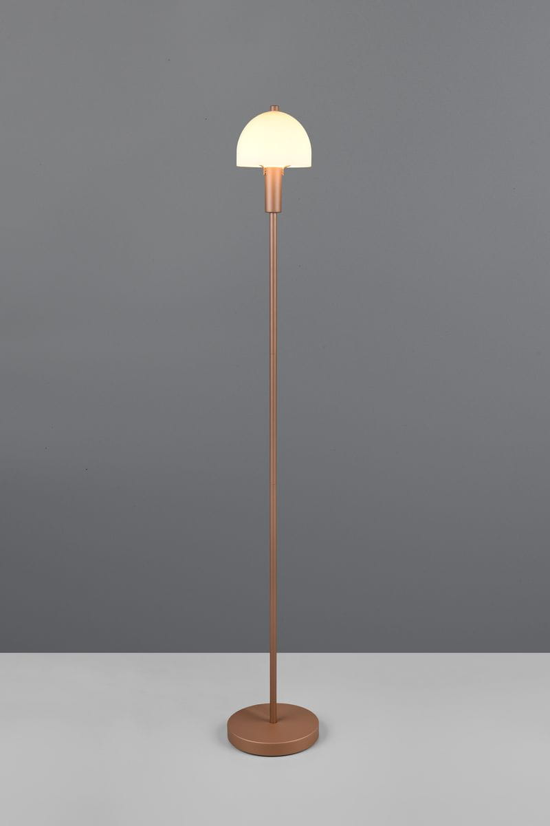 Lampa podłogowa Glenn w kolorze kawowym, z okrągłą podstawą i smukłym stelażem. Klosz w kształcie półkuli z białego materiału, zamontowany na metalowym uchwycie, stojąca na gładkiej powierzchni, na tle szarym.